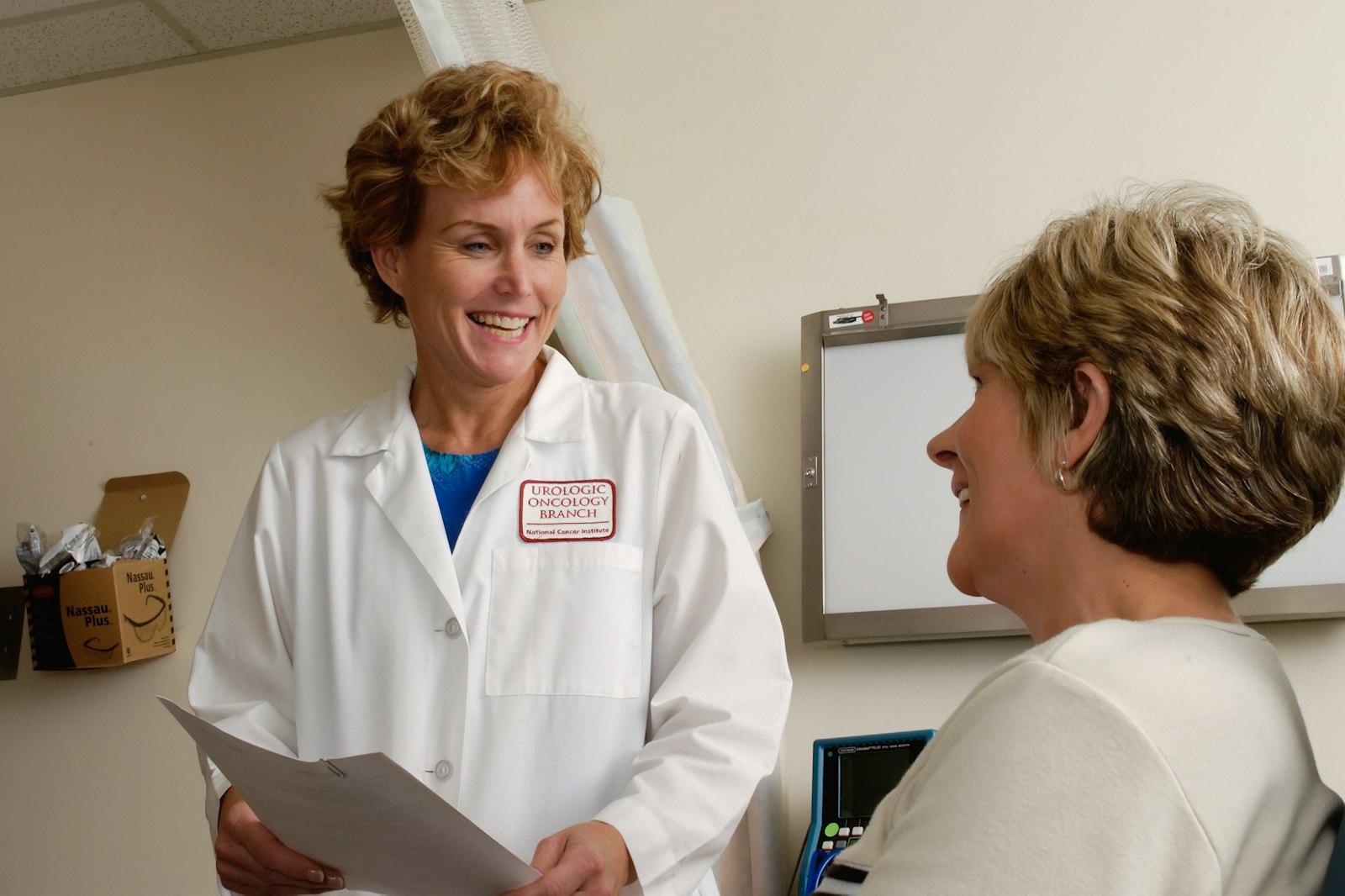 Senior compliance director reviewing customized safety binders with a practice manager in Medical Equipment Facilities